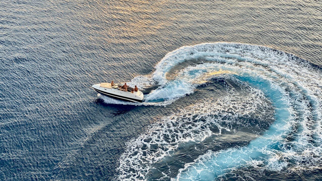 Experience the thrill of a speedboat creating dynamic waves in the Caribbean Sea off Arubas coast.